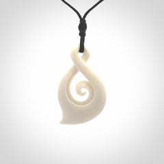 Hand carved twist with koru. Made from natural bone by NZ Pacific. Delivered with an adjustable cord.