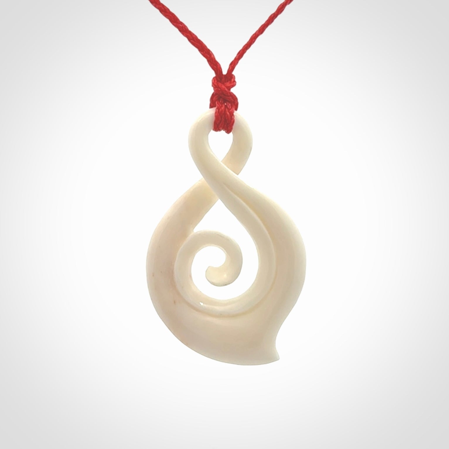 Hand carved twist with koru. Made from natural bone by NZ Pacific. Delivered with an adjustable cord.