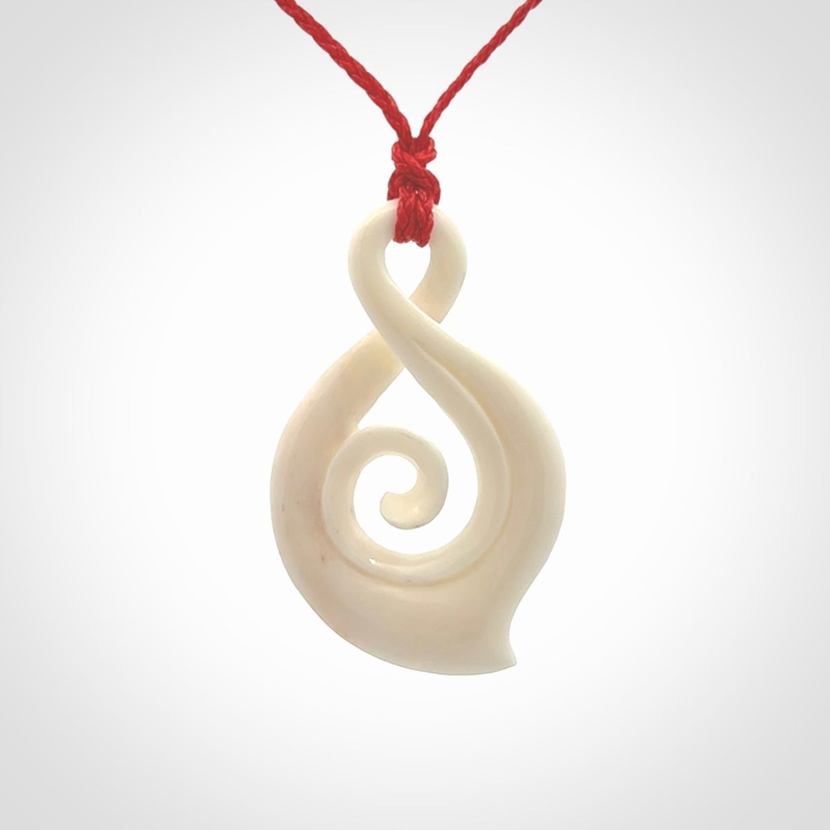 Hand carved twist with koru. Made from natural bone by NZ Pacific. Delivered with an adjustable cord.