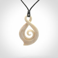 Hand carved twist with koru. Made from natural bone by NZ Pacific. Delivered with an adjustable cord.