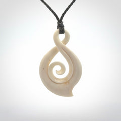 Hand carved twist with koru. Made from natural bone by NZ Pacific. Delivered with an adjustable cord.