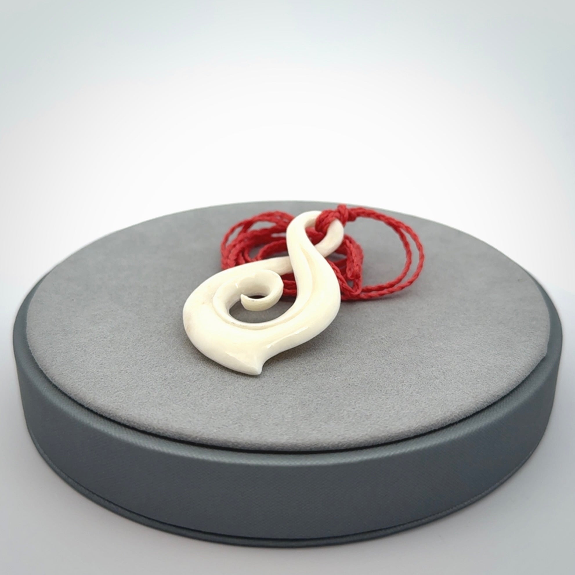 Hand carved twist with koru. Made from natural bone by NZ Pacific. Delivered with an adjustable cord.