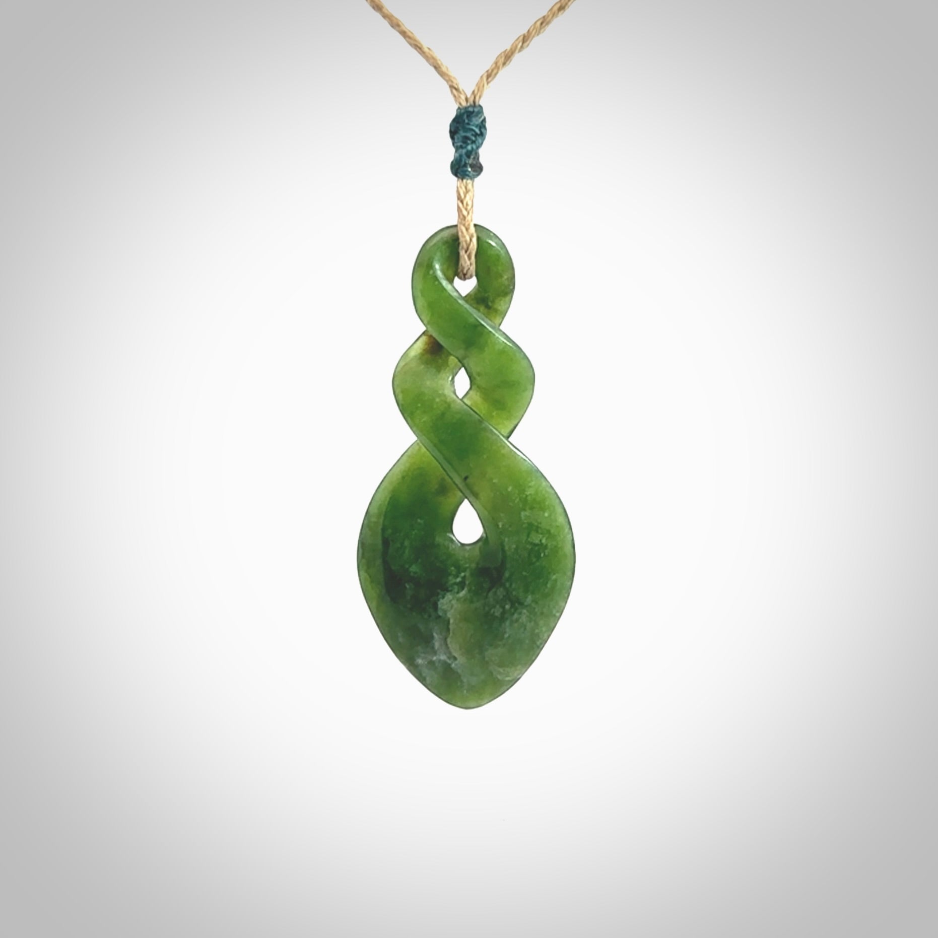 Hand carved New Zealand jade twist pendant. Carved in New Zealand by NZ Pacific. Unique double twist jewellery for sale online. Provided with an adjustable tan cord.