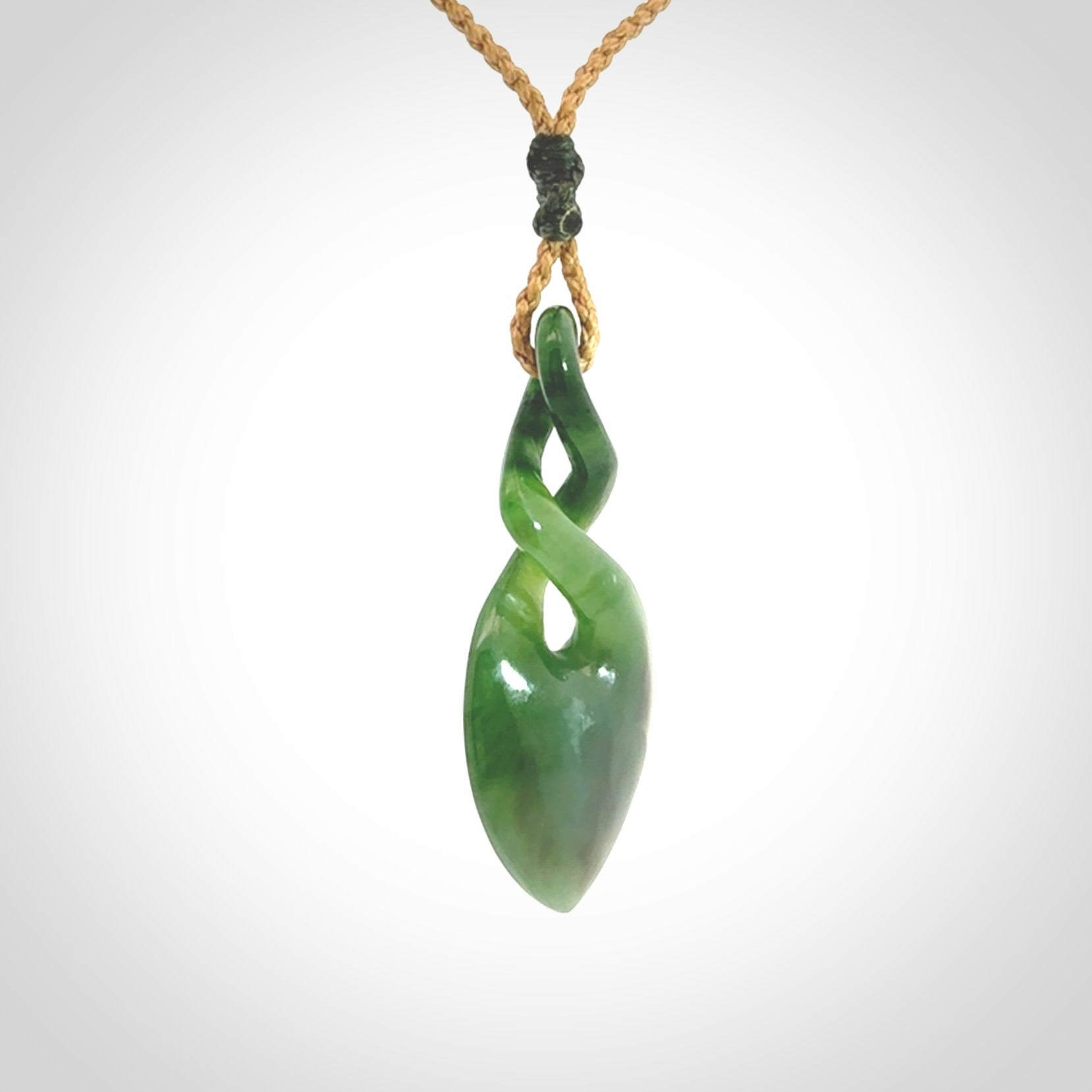 Hand carved New Zealand jade twist pendant. Carved in New Zealand by NZ Pacific. Unique double twist jewellery for sale online. Provided with an adjustable tan cord.
