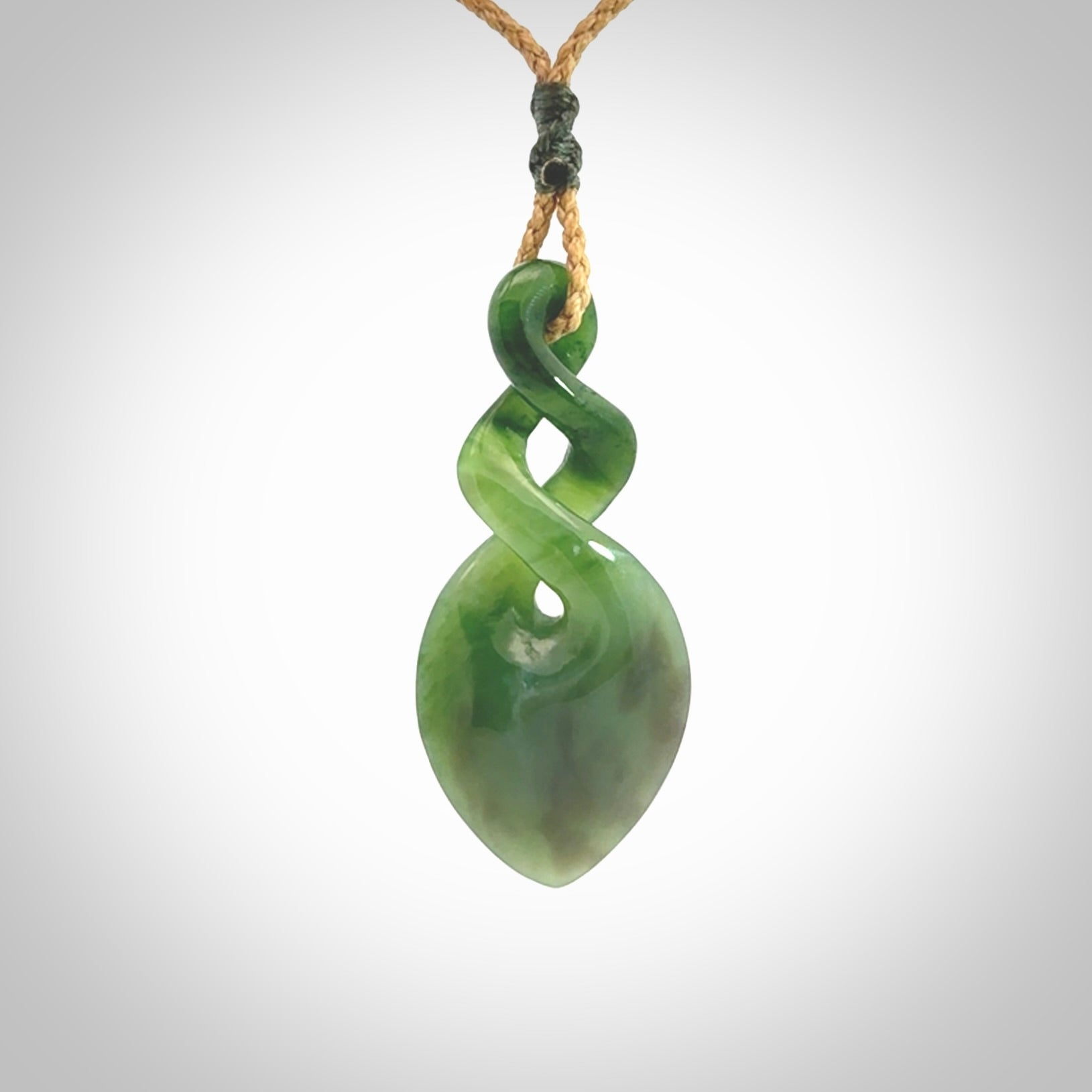 Hand carved New Zealand jade twist pendant. Carved in New Zealand by NZ Pacific. Unique double twist jewellery for sale online. Provided with an adjustable tan cord.