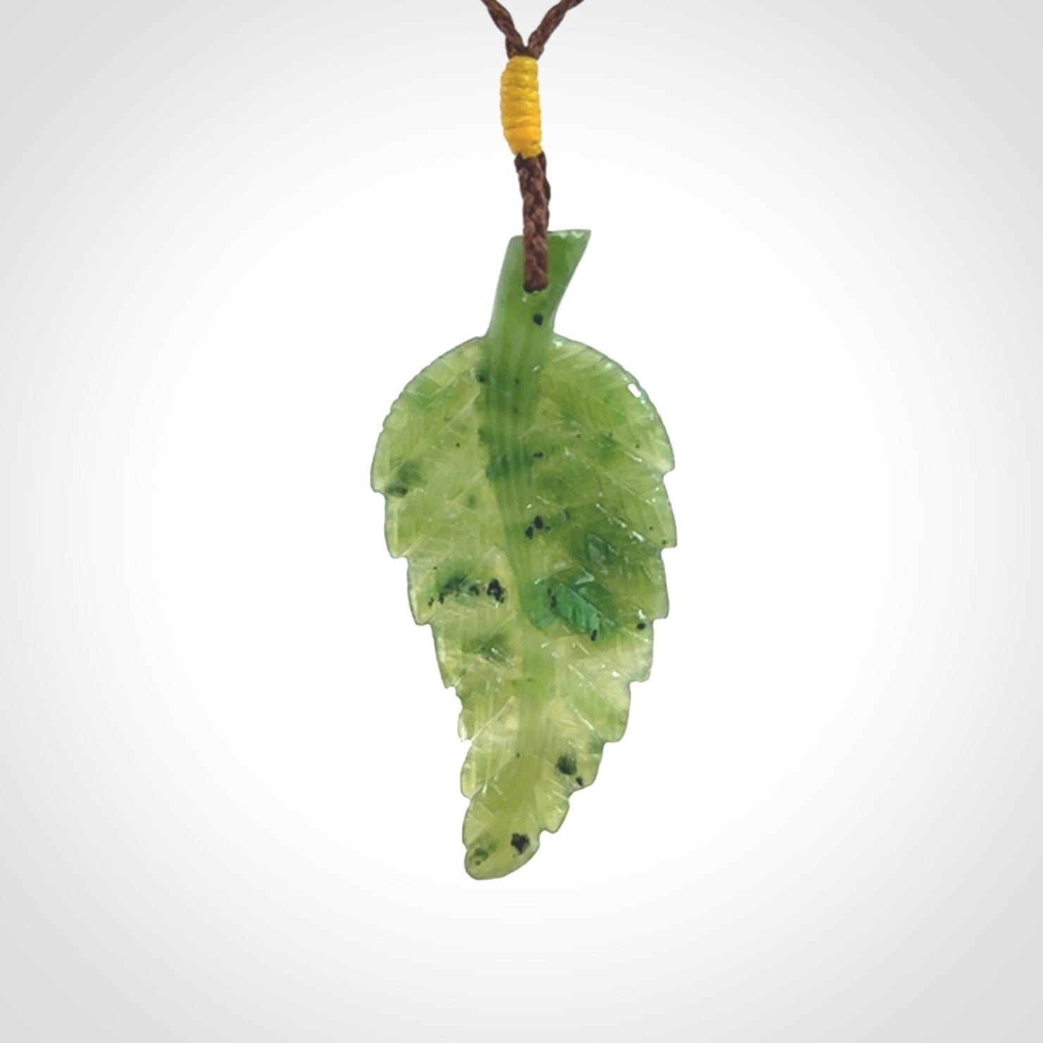 A delicate green jade fern leaf pendant with an adjustable neck cord. Green stone fern leaf necklace with adjustable cord. Delivery included.