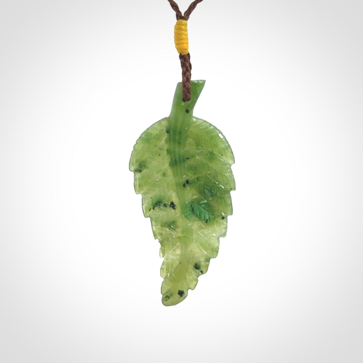 A delicate green jade fern leaf pendant with an adjustable neck cord. Green stone fern leaf necklace with adjustable cord. Delivery included.