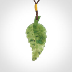 A delicate green jade fern leaf pendant with an adjustable neck cord. Green stone fern leaf necklace with adjustable cord. Delivery included.