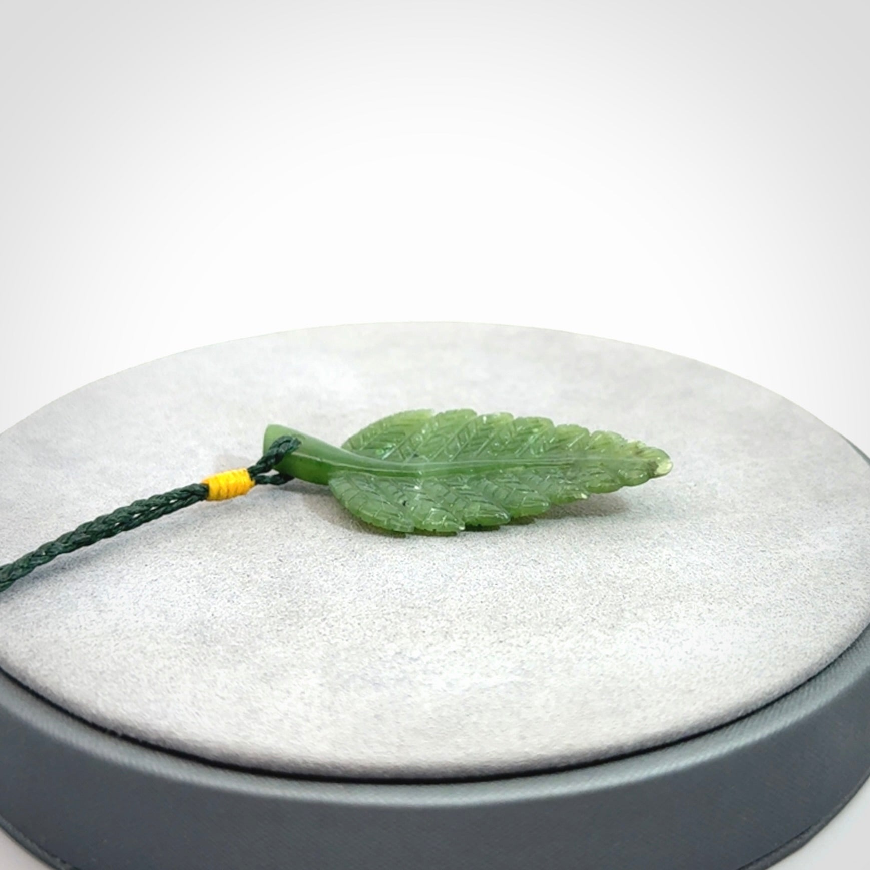 A delicate green jade fern leaf pendant with an adjustable neck cord. Green stone fern leaf necklace with adjustable cord. Delivery included.