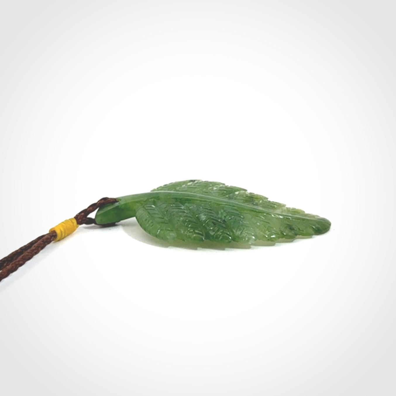 A delicate green jade fern leaf pendant with an adjustable neck cord. Green stone fern leaf necklace with adjustable cord. Delivery included.