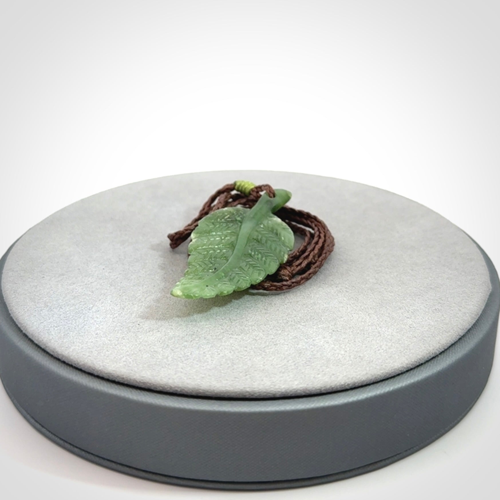 A delicate green jade fern leaf pendant with an adjustable neck cord. Green stone fern leaf necklace with adjustable cord. Delivery included.