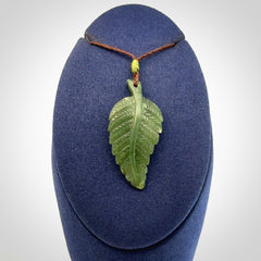 A delicate green jade fern leaf pendant with an adjustable neck cord. Green stone fern leaf necklace with adjustable cord. Delivery included.