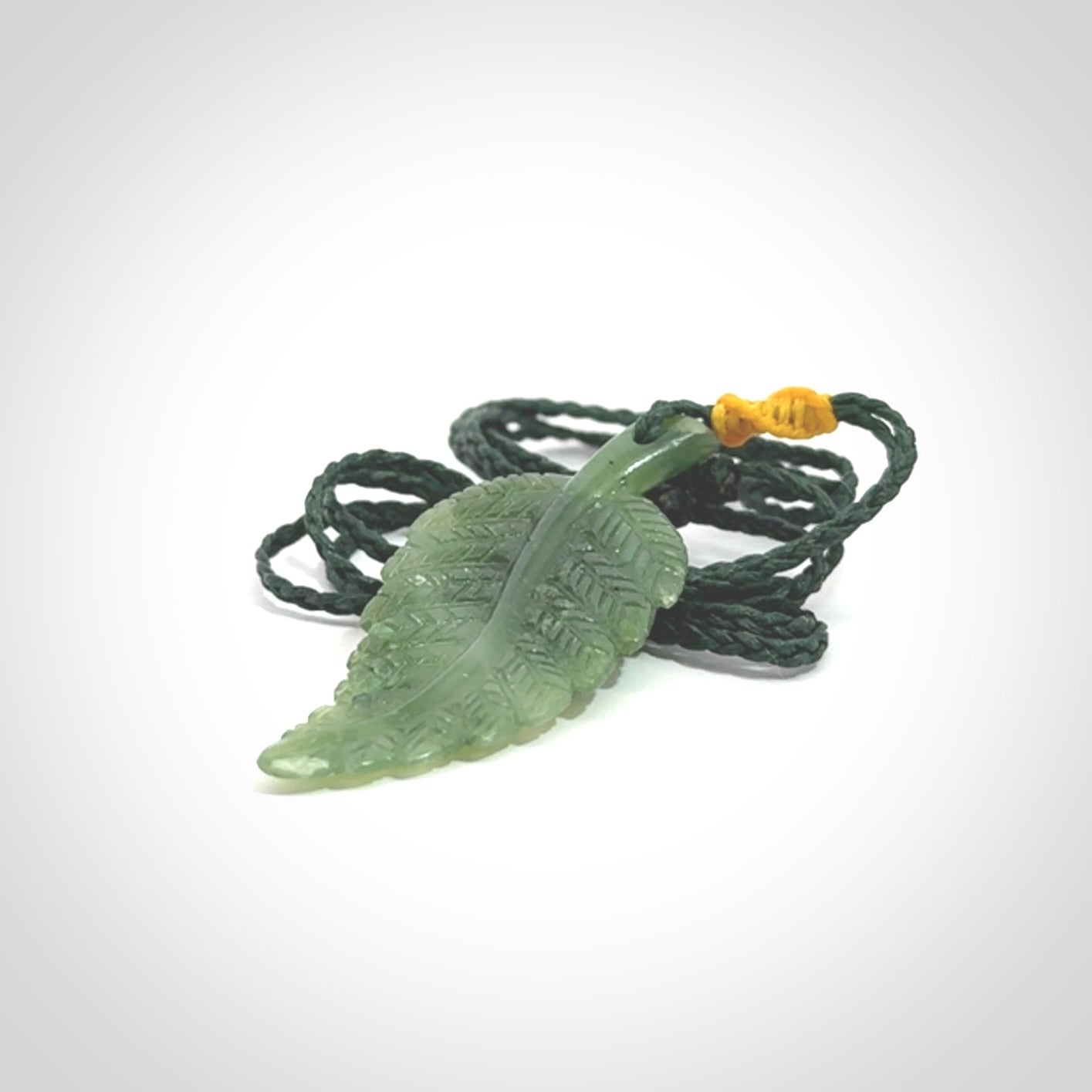 A delicate green jade fern leaf pendant with an adjustable neck cord. Green stone fern leaf necklace with adjustable cord. Delivery included.
