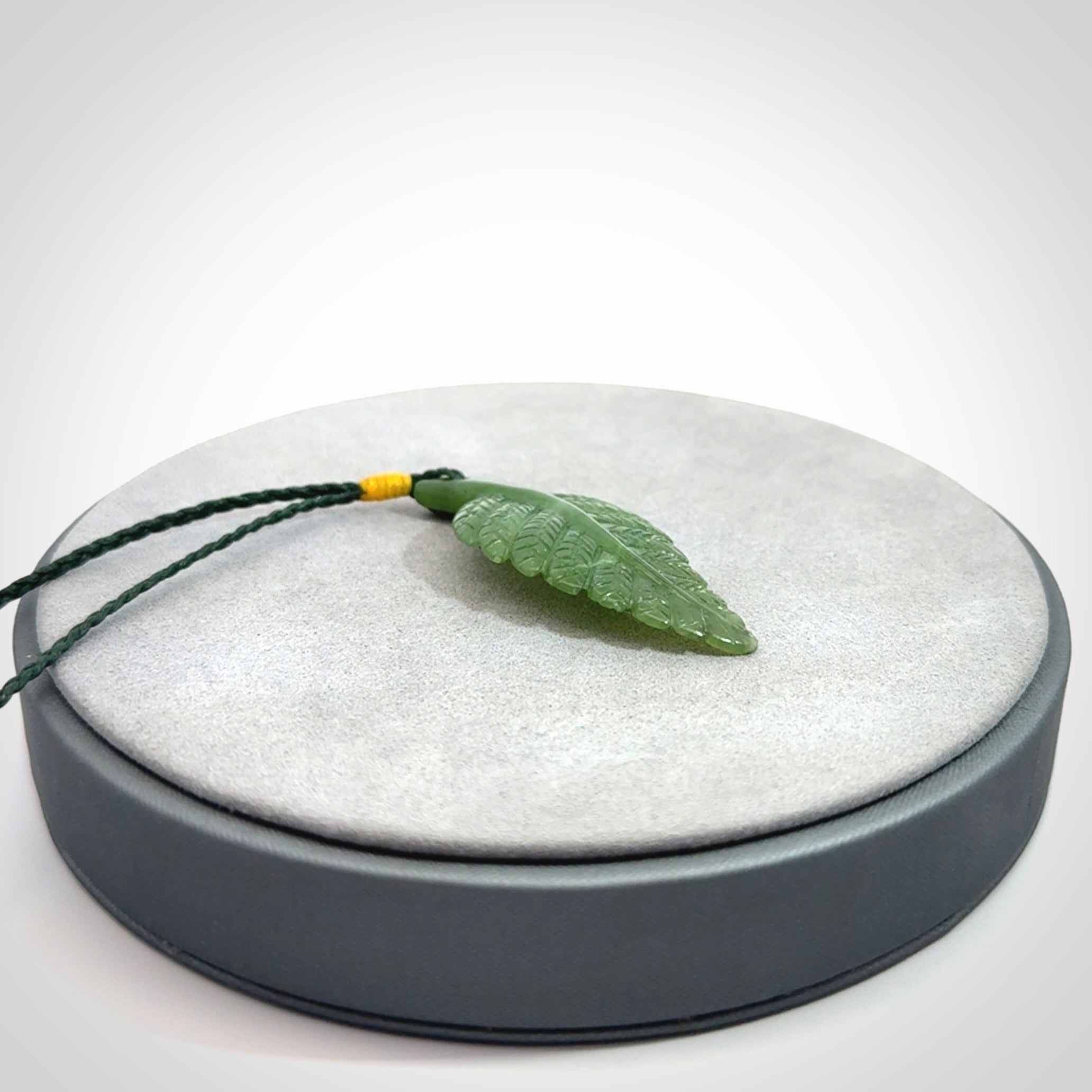 A delicate green jade fern leaf pendant with an adjustable neck cord. Green stone fern leaf necklace with adjustable cord. Delivery included.