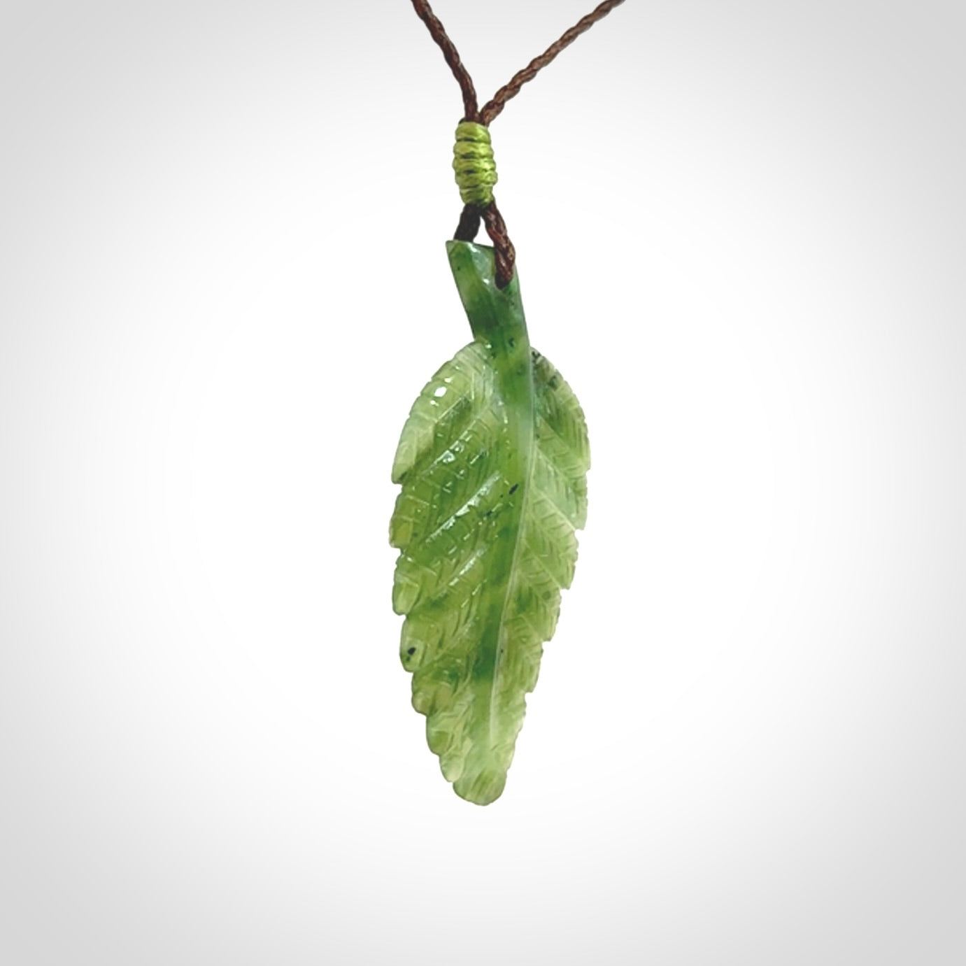 A delicate green jade fern leaf pendant with an adjustable neck cord. Green stone fern leaf necklace with adjustable cord. Delivery included.
