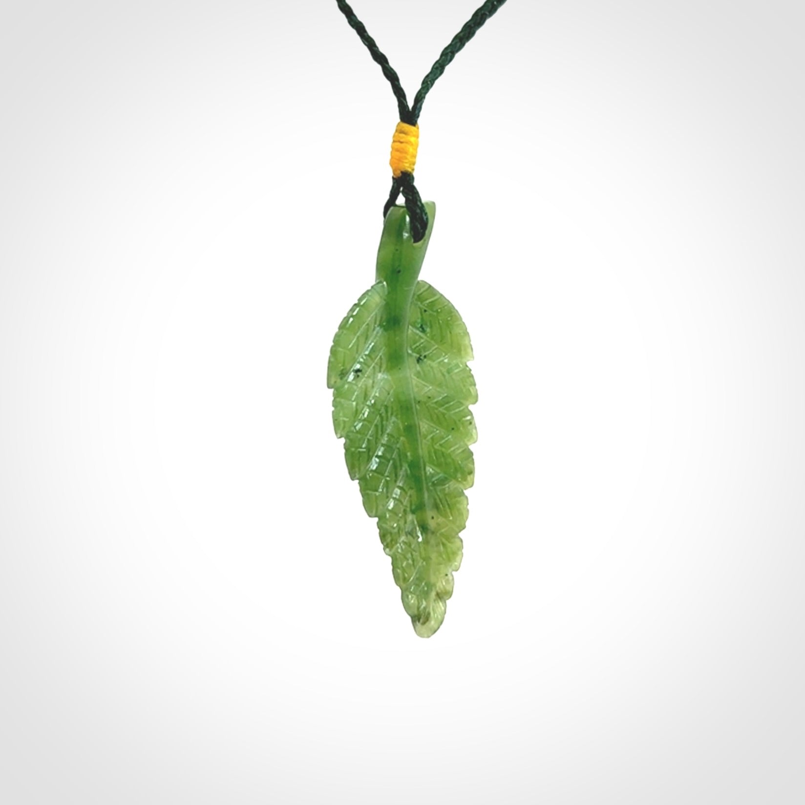 A delicate green jade fern leaf pendant with an adjustable neck cord. Green stone fern leaf necklace with adjustable cord. Delivery included.