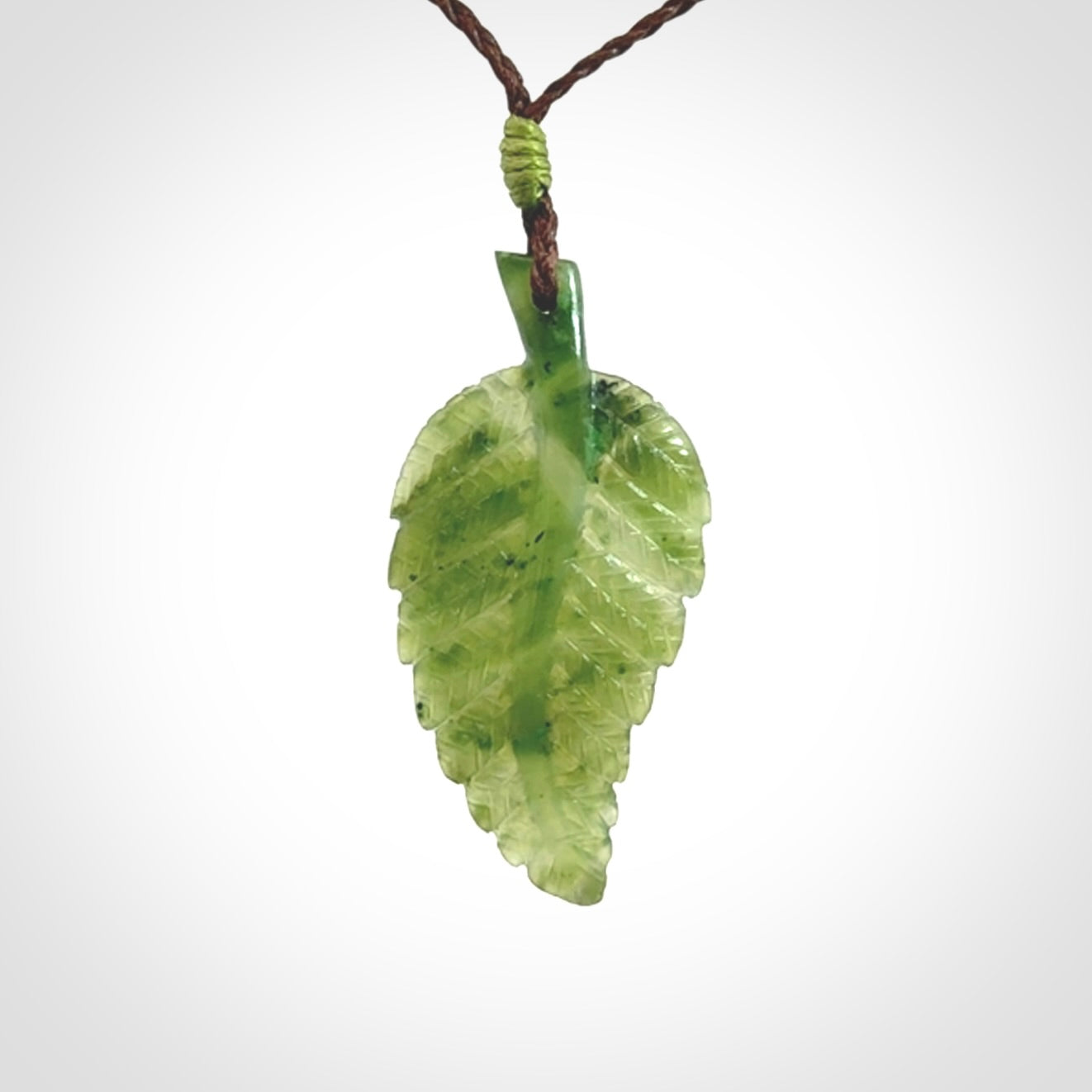 A delicate green jade fern leaf pendant with an adjustable neck cord. Green stone fern leaf necklace with adjustable cord. Delivery included.