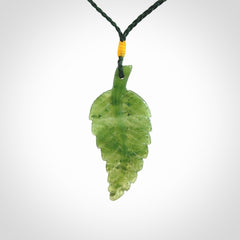 A delicate green jade fern leaf pendant with an adjustable neck cord. Green stone fern leaf necklace with adjustable cord. Delivery included.