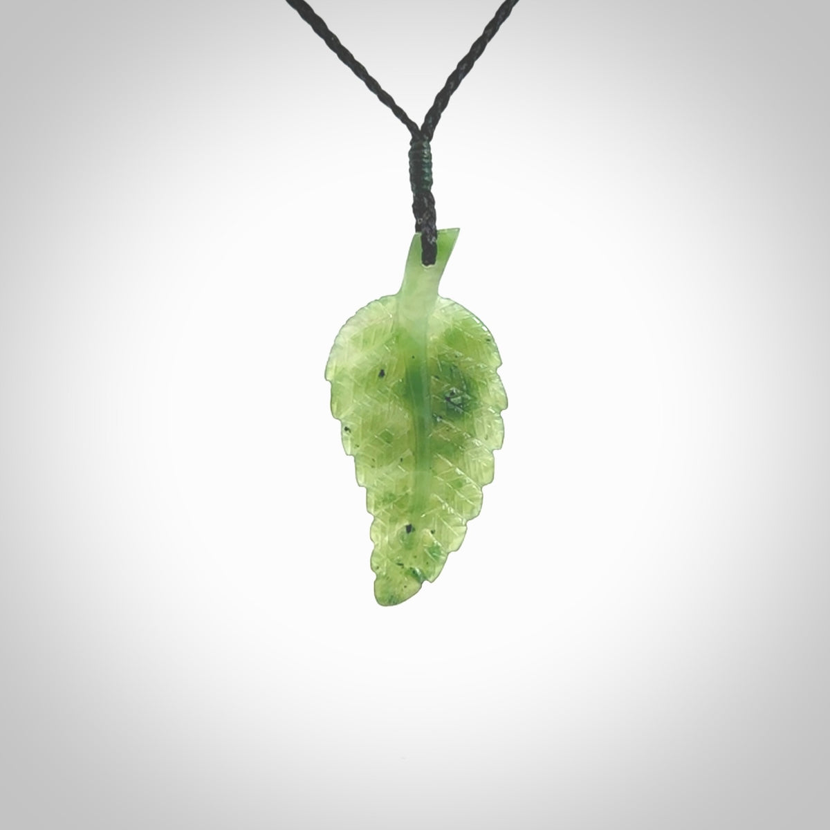A delicate green jade fern leaf pendant with an adjustable neck cord. Green stone fern leaf necklace with adjustable cord. Delivery included.