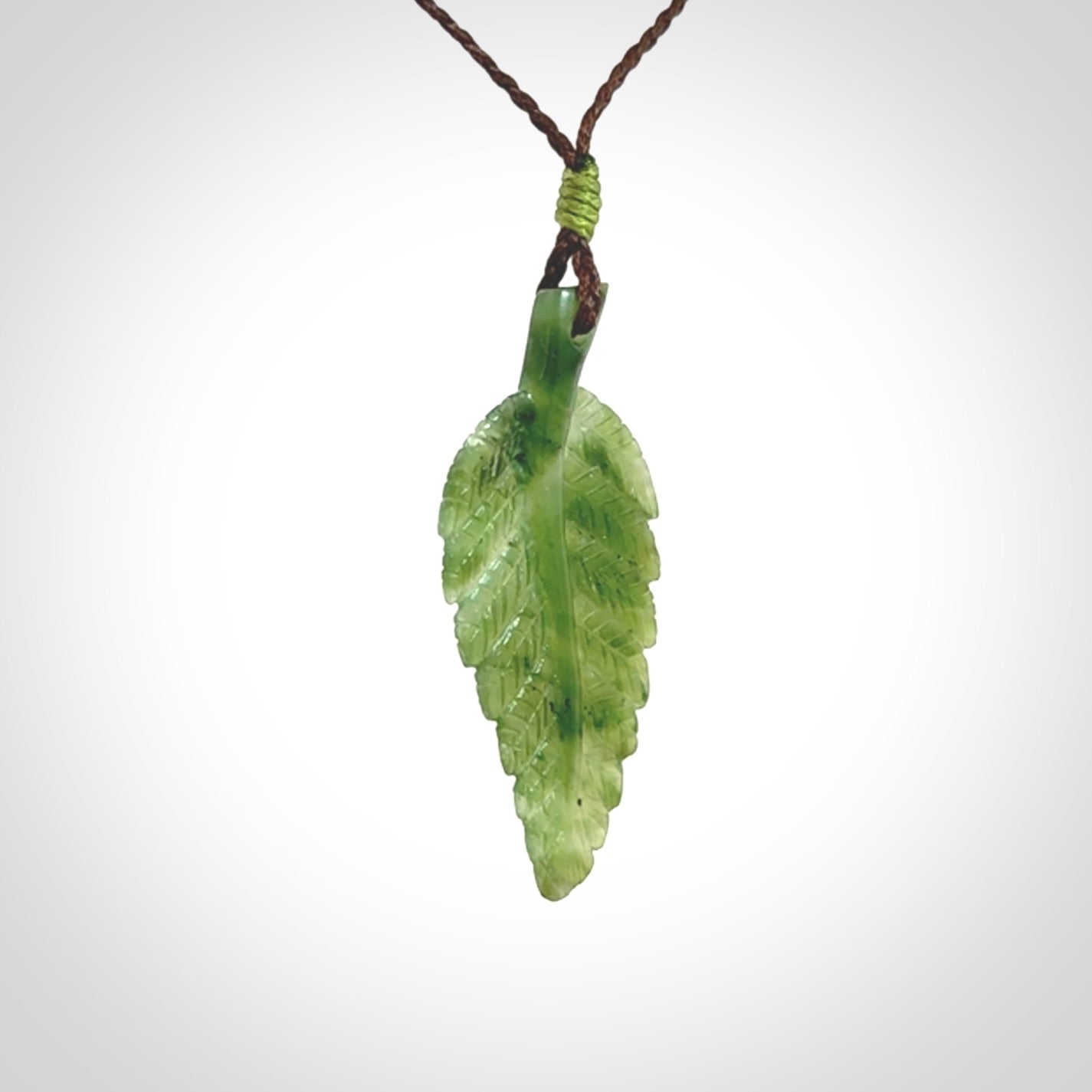 A delicate green jade fern leaf pendant with an adjustable neck cord. Green stone fern leaf necklace with adjustable cord. Delivery included.