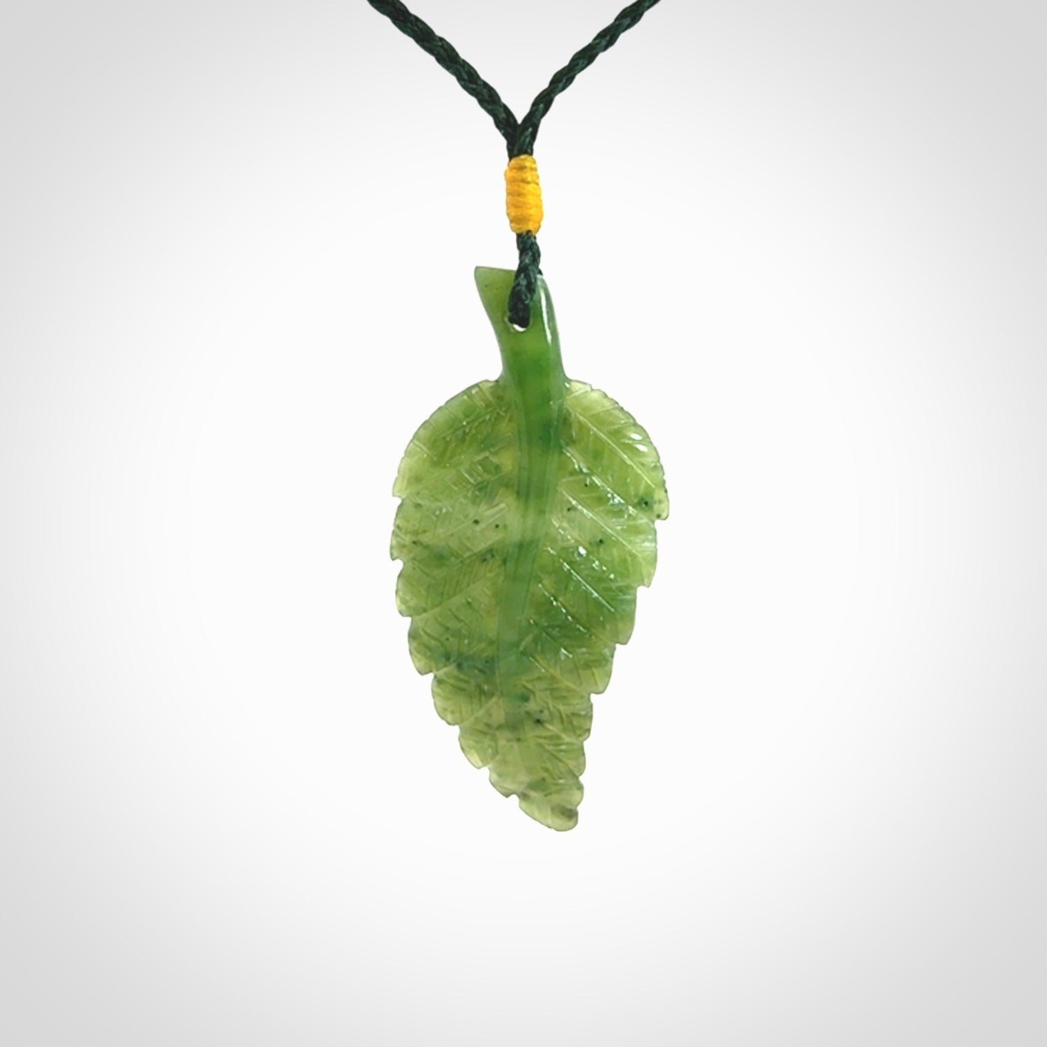 A delicate green jade fern leaf pendant with an adjustable neck cord. Green stone fern leaf necklace with adjustable cord. Delivery included.