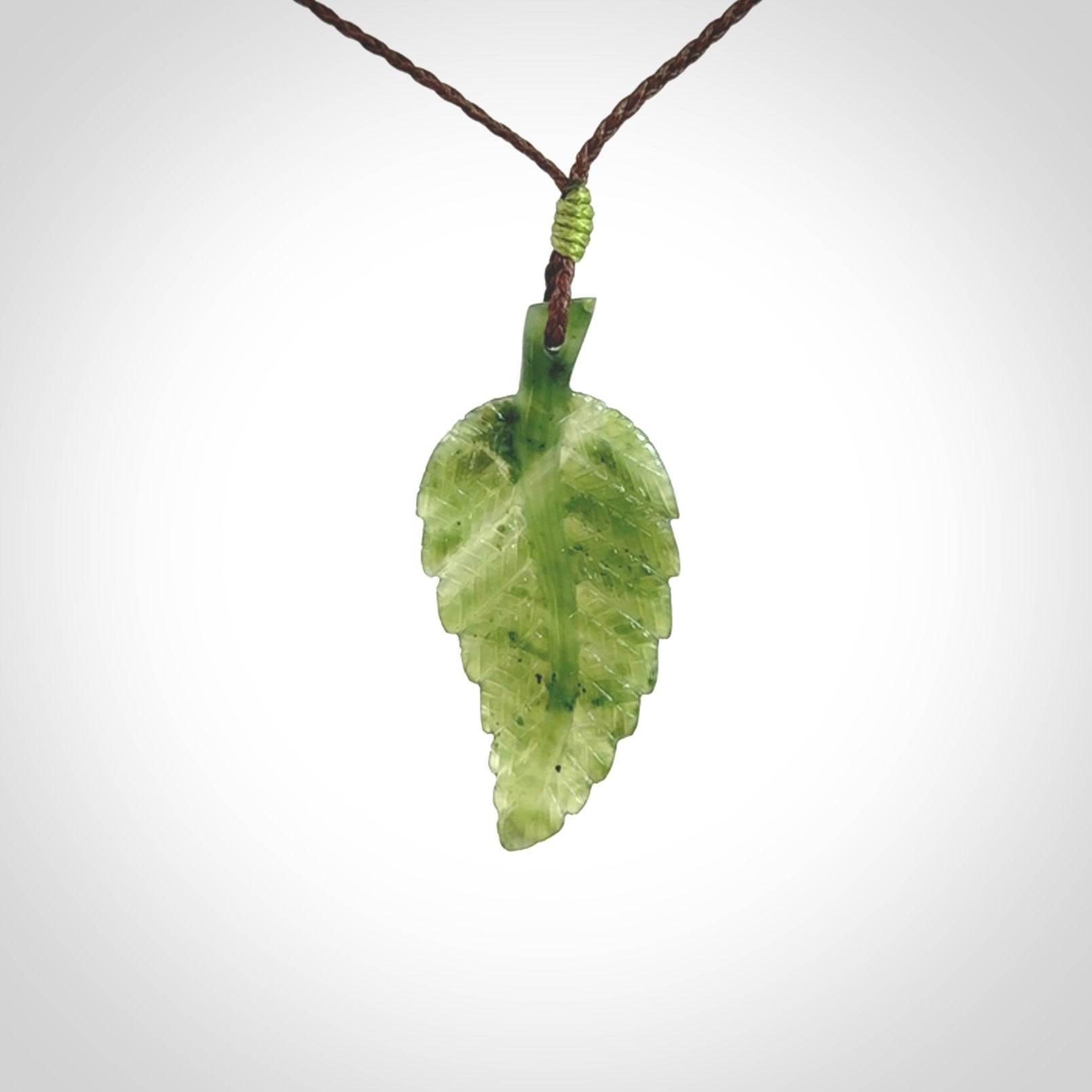 A delicate green jade fern leaf pendant with an adjustable neck cord. Green stone fern leaf necklace with adjustable cord. Delivery included.