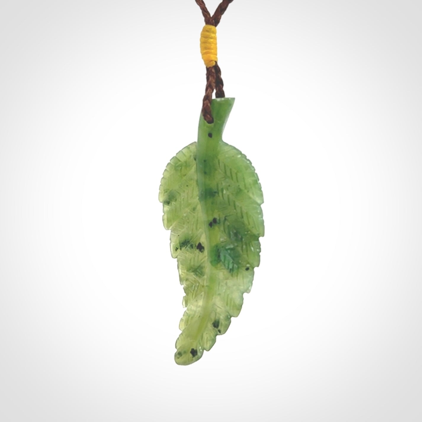 A delicate green jade fern leaf pendant with an adjustable neck cord. Green stone fern leaf necklace with adjustable cord. Delivery included.