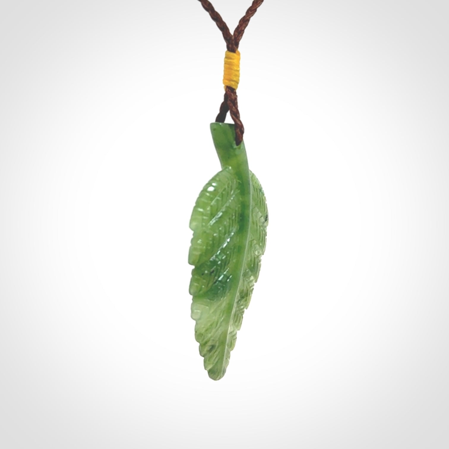A delicate green jade fern leaf pendant with an adjustable neck cord. Green stone fern leaf necklace with adjustable cord. Delivery included.