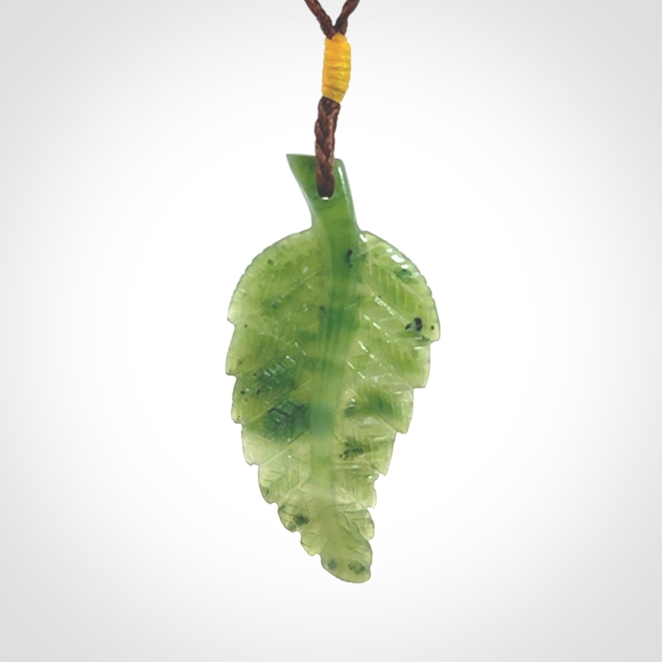 A delicate green jade fern leaf pendant with an adjustable neck cord. Green stone fern leaf necklace with adjustable cord. Delivery included.