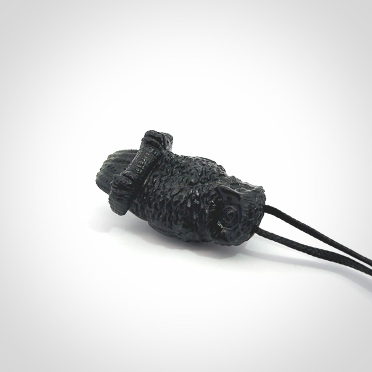 A traditional Owl design carving, hand made for us from Australian Black Jade. This is a work of art and is a collectable piece of traditional Black Jade carving. It can be worn as a special piece of jewellery or displayed. This is art made to wear at its finest. A unisex pendant for owl lovers. This pendant is provided with an adjustable cord.