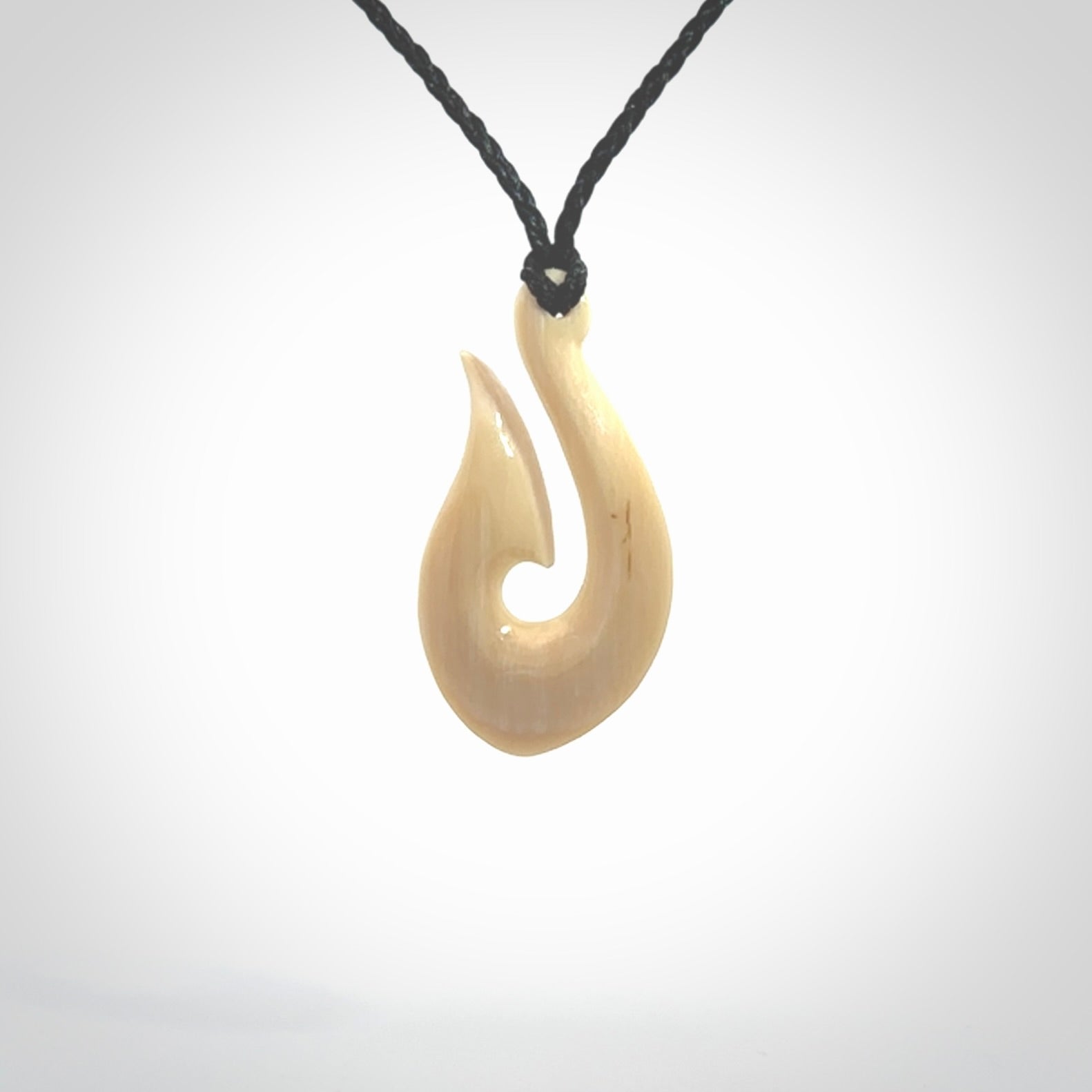 A fish hook necklace (hei-matau) hand-carved in a traditional style from Woolly Mammoth Tusk. These are glorious pieces of art to wear. Provided with adjustable cords and packaged in a woven kete pouch. Delivered with express courier.