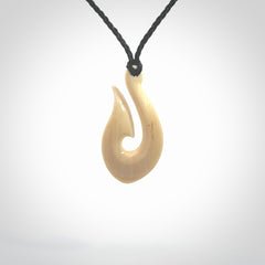 A fish hook necklace (hei-matau) hand-carved in a traditional style from Woolly Mammoth Tusk. These are glorious pieces of art to wear. Provided with adjustable cords and packaged in a woven kete pouch. Delivered with express courier.