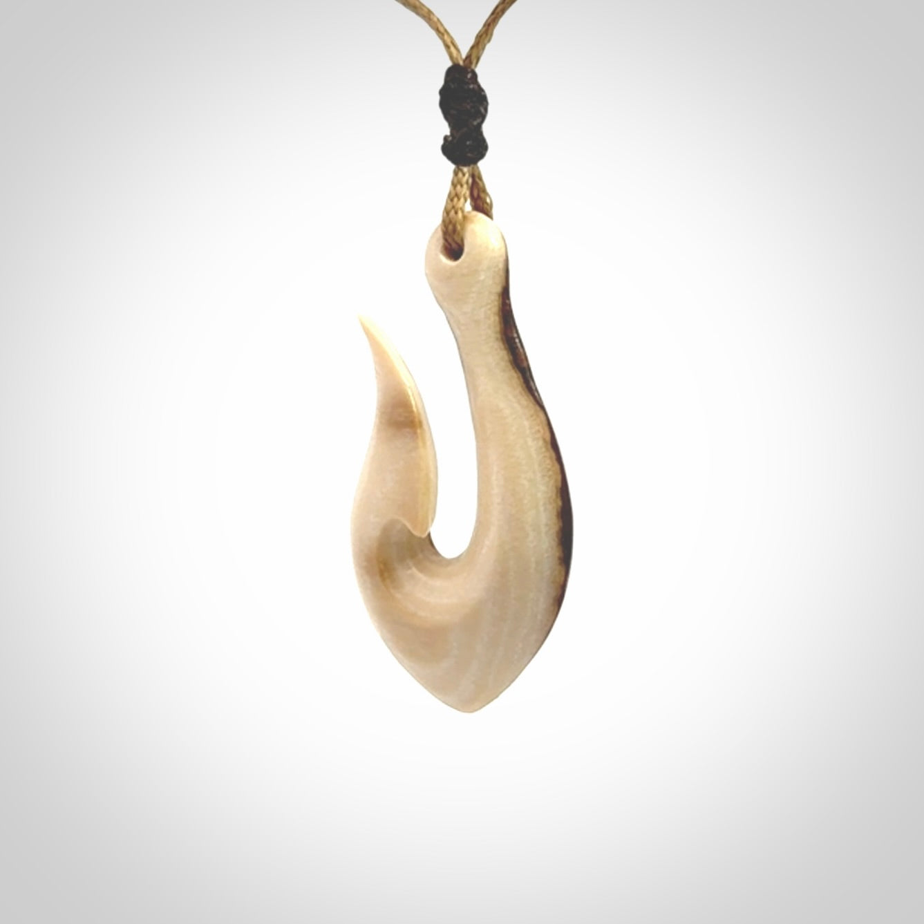 A fish hook necklace (hei-matau) hand-carved in a traditional style from Woolly Mammoth Tusk. These are glorious pieces of art to wear. Provided with adjustable cords and packaged in a woven kete pouch. Delivered with express courier.