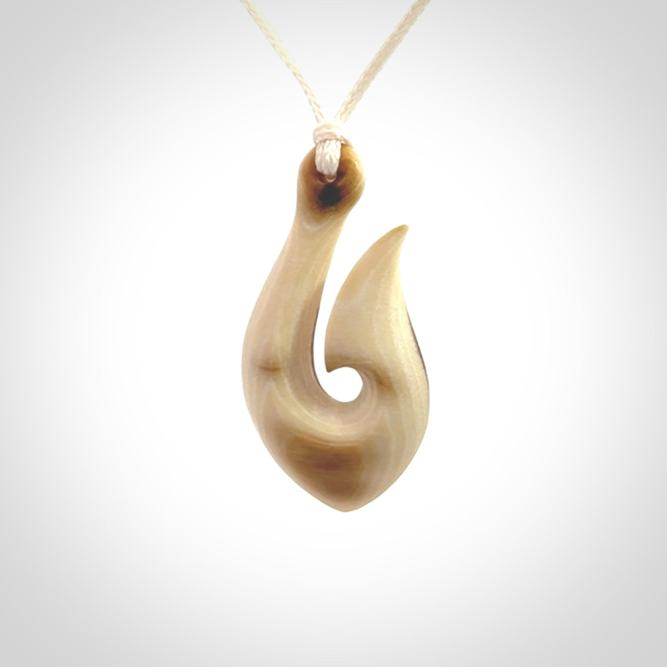 A fish hook necklace (hei-matau) hand-carved in a traditional style from Woolly Mammoth Tusk. These are glorious pieces of art to wear. Provided with adjustable cords and packaged in a woven kete pouch. Delivered with express courier.