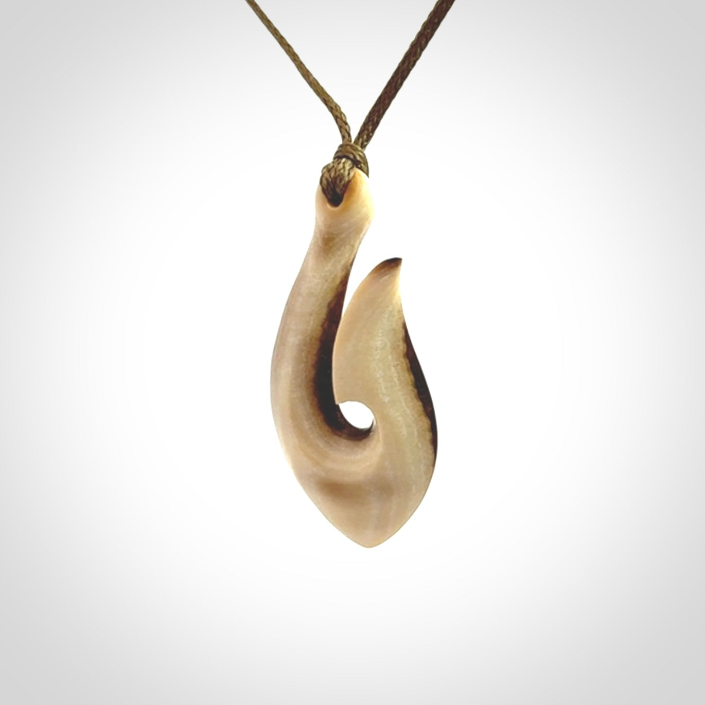 A fish hook necklace (hei-matau) hand-carved in a traditional style from Woolly Mammoth Tusk. These are glorious pieces of art to wear. Provided with adjustable cords and packaged in a woven kete pouch. Delivered with express courier.