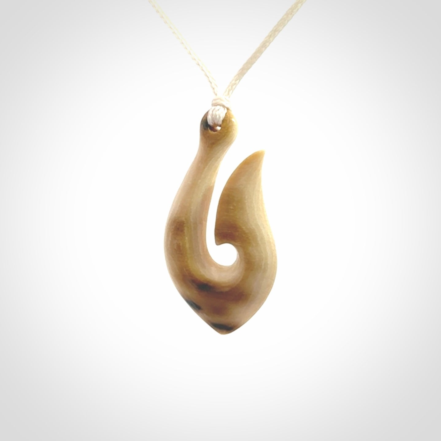 A fish hook necklace (hei-matau) hand-carved in a traditional style from Woolly Mammoth Tusk. These are glorious pieces of art to wear. Provided with adjustable cords and packaged in a woven kete pouch. Delivered with express courier.