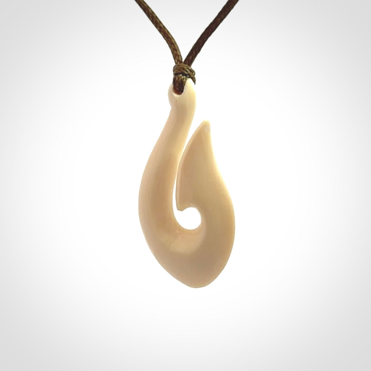 A fish hook necklace (hei-matau) hand-carved in a traditional style from Woolly Mammoth Tusk. These are glorious pieces of art to wear. Provided with adjustable cords and packaged in a woven kete pouch