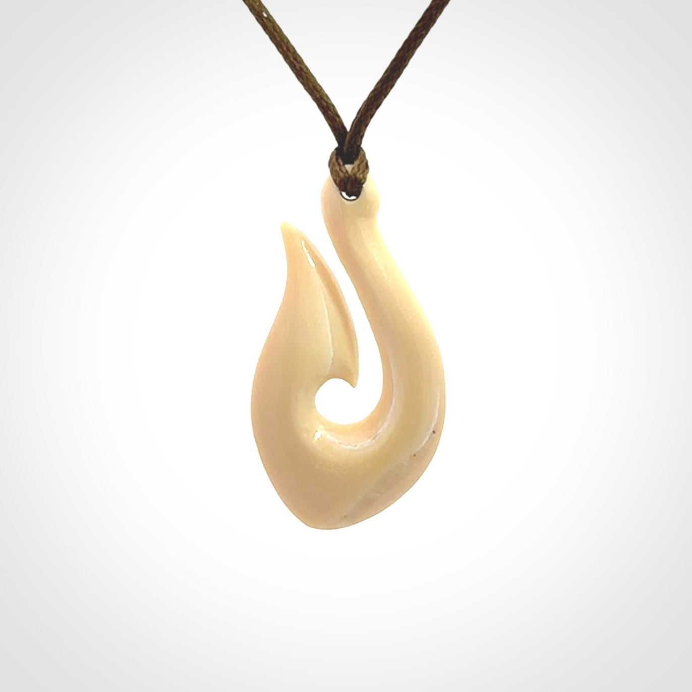 A fish hook necklace (hei-matau) hand-carved in a traditional style from Woolly Mammoth Tusk. These are glorious pieces of art to wear. Provided with adjustable cords and packaged in a woven kete pouch