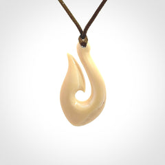 A fish hook necklace (hei-matau) hand-carved in a traditional style from Woolly Mammoth Tusk. These are glorious pieces of art to wear. Provided with adjustable cords and packaged in a woven kete pouch