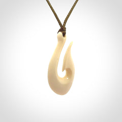 A fish hook necklace (hei-matau) hand-carved in a traditional style from Woolly Mammoth Tusk. These are glorious pieces of art to wear. Provided with adjustable cords and packaged in a woven kete pouch