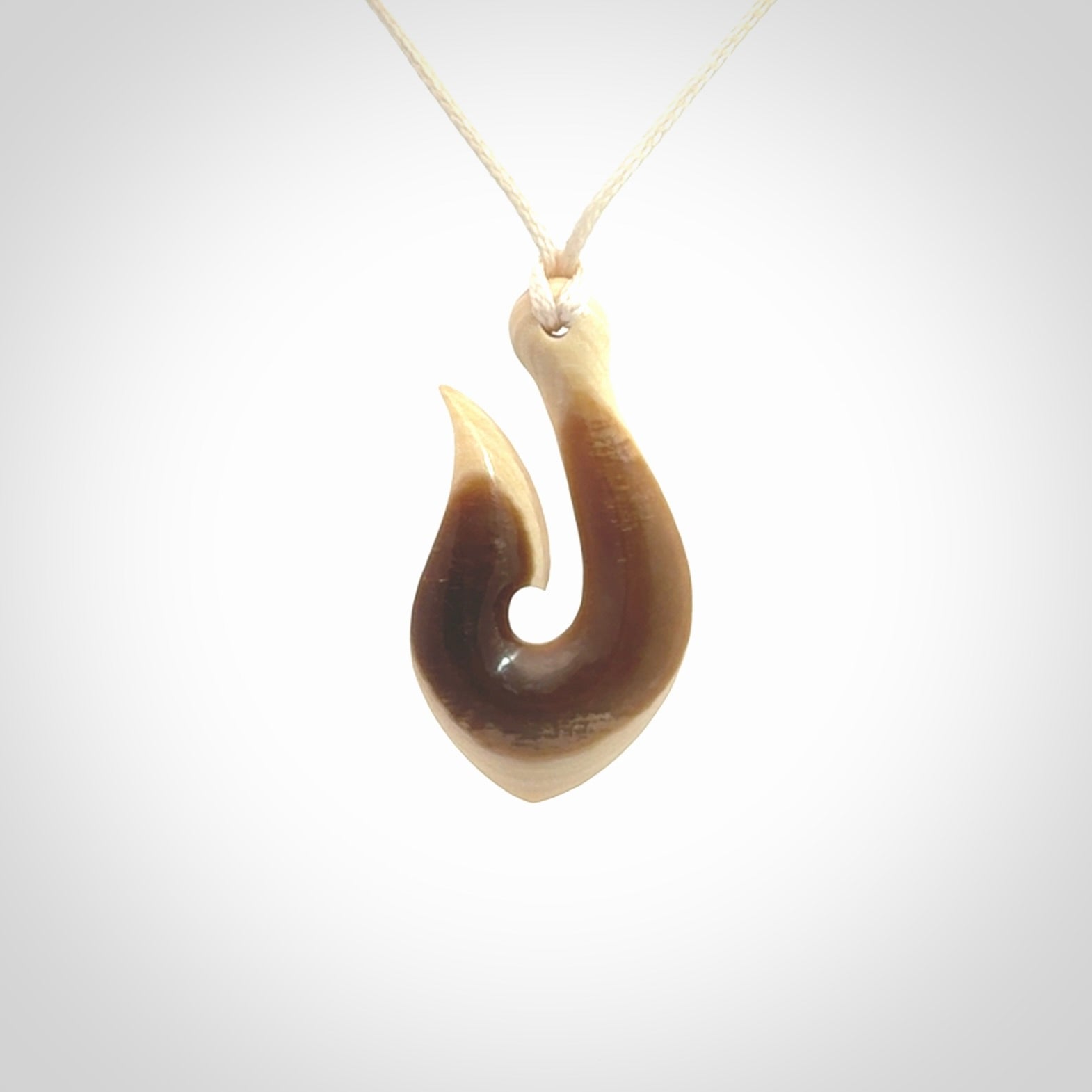 A fish hook necklace (hei-matau) hand-carved in a traditional style from Woolly Mammoth Tusk. These are glorious pieces of art to wear. Provided with adjustable cords and packaged in a woven kete pouch. Delivered with express courier.