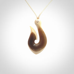 A fish hook necklace (hei-matau) hand-carved in a traditional style from Woolly Mammoth Tusk. These are glorious pieces of art to wear. Provided with adjustable cords and packaged in a woven kete pouch. Delivered with express courier.
