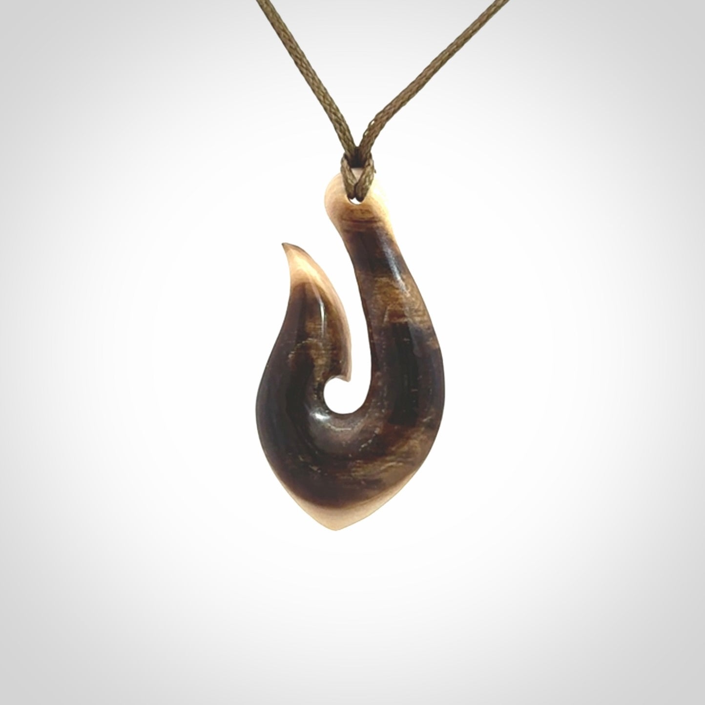 A fish hook necklace (hei-matau) hand-carved in a traditional style from Woolly Mammoth Tusk. These are glorious pieces of art to wear. Provided with adjustable cords and packaged in a woven kete pouch. Delivered with express courier.