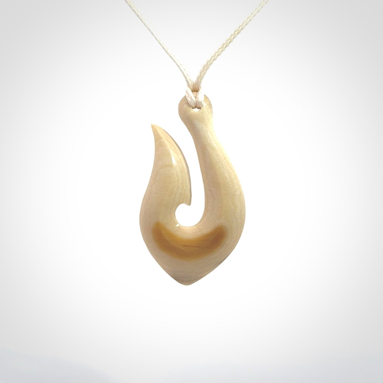A fish hook necklace (hei-matau) hand-carved in a traditional style from Woolly Mammoth Tusk. These are glorious pieces of art to wear. Provided with adjustable cords and packaged in a woven kete pouch. Delivered with express courier.