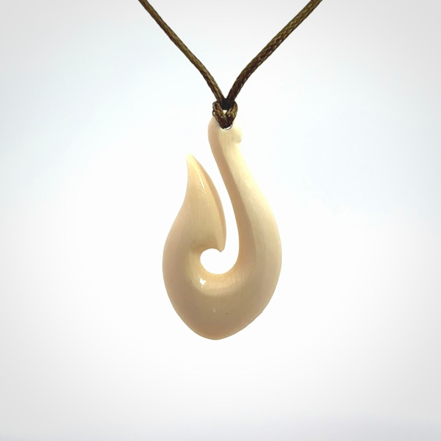 A fish hook necklace (hei-matau) hand-carved in a traditional style from Woolly Mammoth Tusk. These are glorious pieces of art to wear. Provided with adjustable cords and packaged in a woven kete pouch