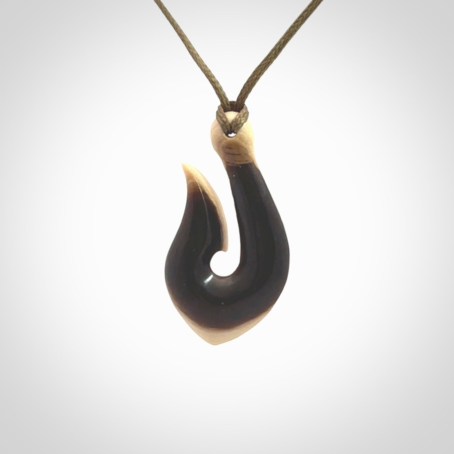 A fish hook necklace (hei-matau) hand-carved in a traditional style from Woolly Mammoth Tusk. These are glorious pieces of art to wear. Provided with adjustable cords and packaged in a woven kete pouch. Delivered with express courier.