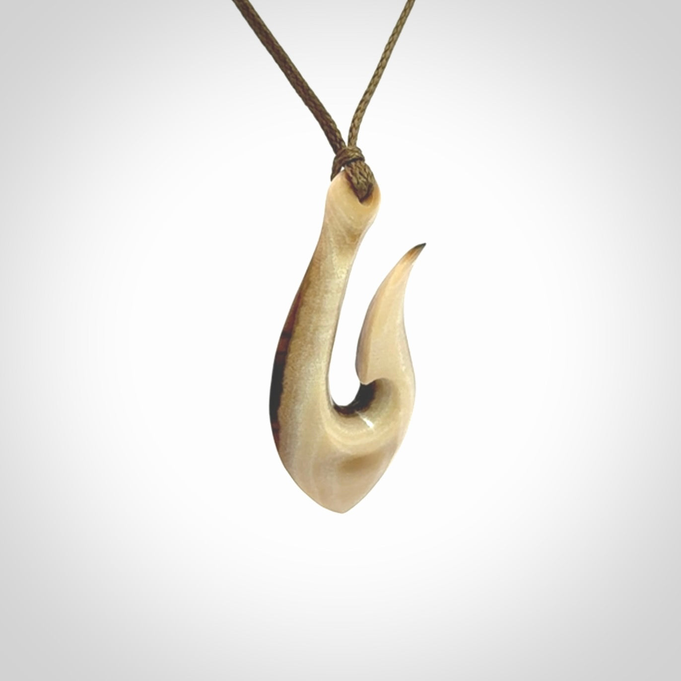 A fish hook necklace (hei-matau) hand-carved in a traditional style from Woolly Mammoth Tusk. These are glorious pieces of art to wear. Provided with adjustable cords and packaged in a woven kete pouch. Delivered with express courier.