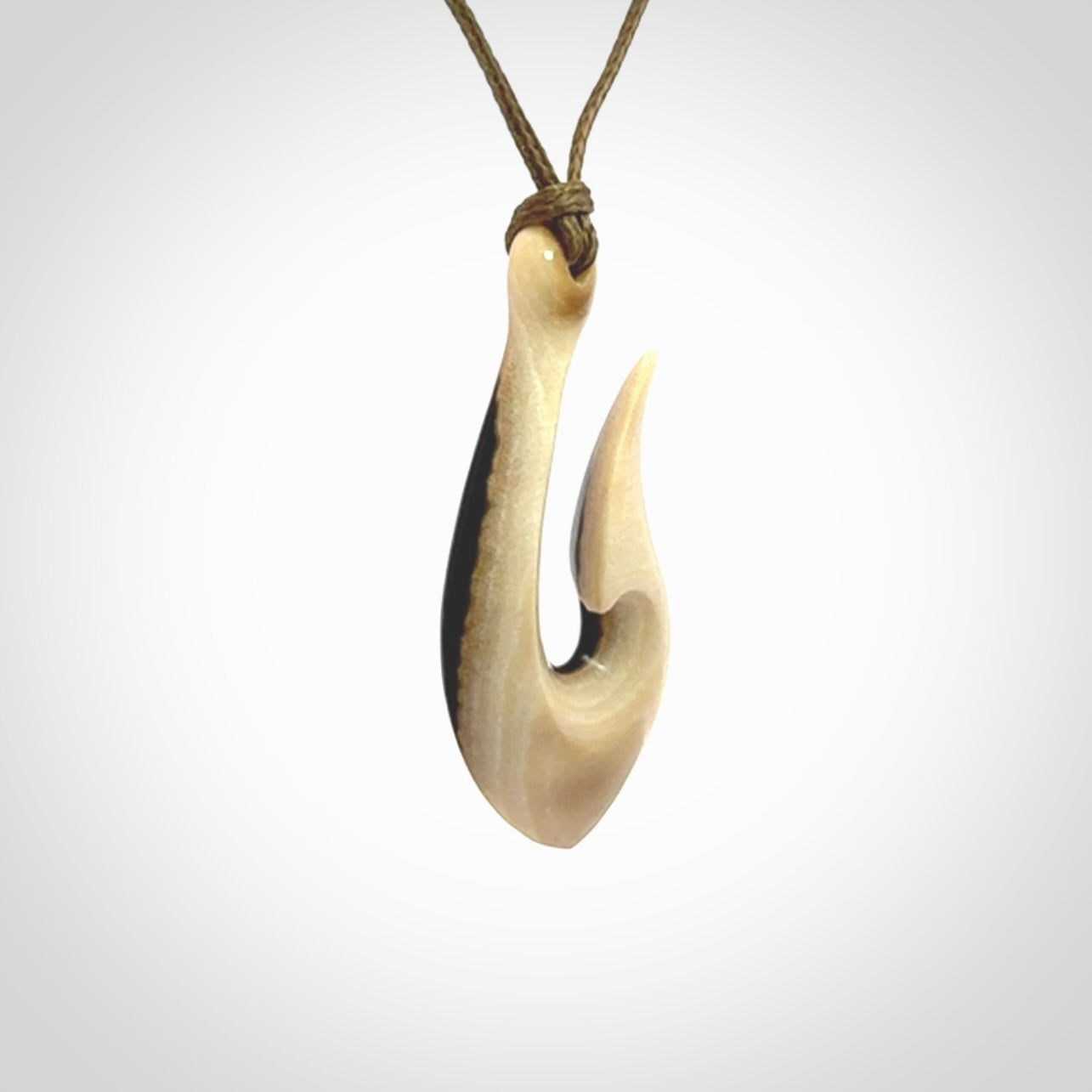 A fish hook necklace (hei-matau) hand-carved in a traditional style from Woolly Mammoth Tusk. These are glorious pieces of art to wear. Provided with adjustable cords and packaged in a woven kete pouch. Delivered with express courier.