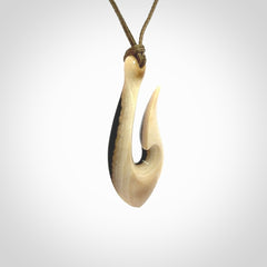 A fish hook necklace (hei-matau) hand-carved in a traditional style from Woolly Mammoth Tusk. These are glorious pieces of art to wear. Provided with adjustable cords and packaged in a woven kete pouch. Delivered with express courier.