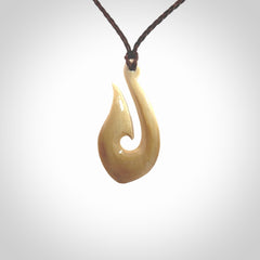 A fish hook necklace (hei-matau) hand-carved in a traditional style from Woolly Mammoth Tusk. These are glorious pieces of art to wear. Provided with adjustable cords and packaged in a woven kete pouch. Delivered with express courier.